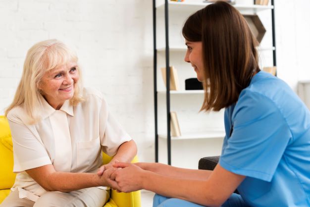 medium-shot-old-woman-nurse-holding-hands